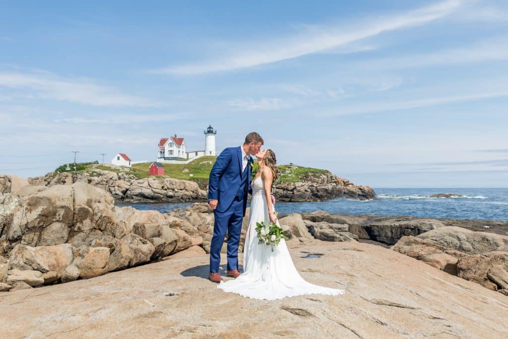 A happy Maine couple getting married near a lighthouse